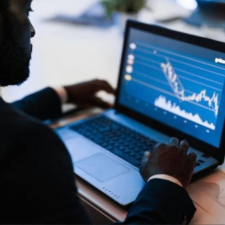 Analyst monitoring sanctions and transaction data on a laptop dashboard