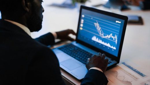 Analyst monitoring sanctions and transaction data on a laptop dashboard