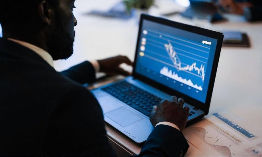 Analyst monitoring sanctions and transaction data on a laptop dashboard